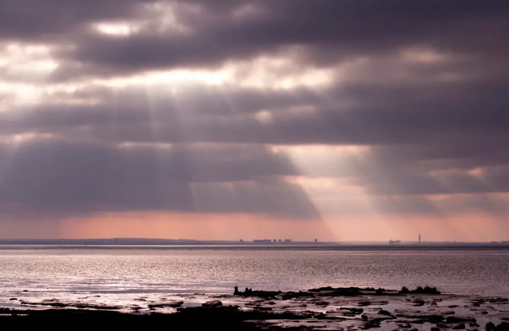 Alcohol Rehab Grimsby. An image of Grimsby across the River Humber from Spurn Point, East Yorkshire, showing sunburst and clouds.