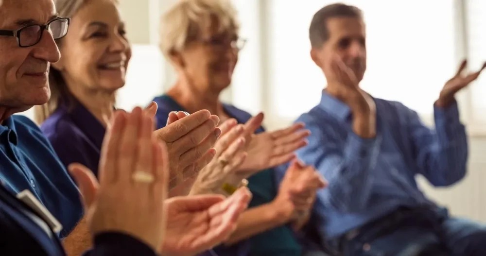 Group of people in support group clapping