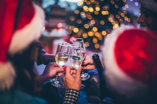 People drinking around Christmas tree