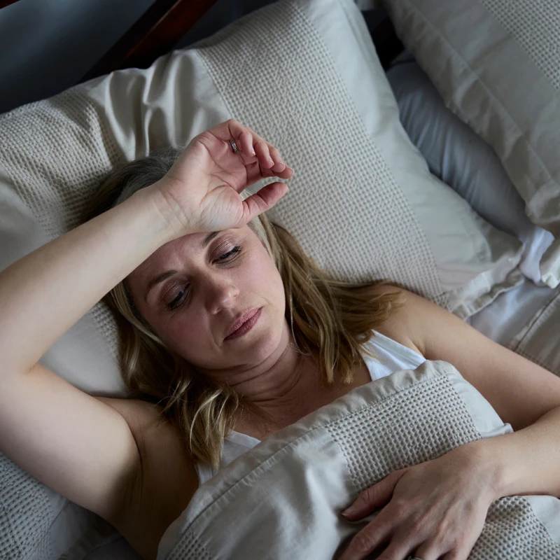 Is Melatonin Addictive? A woman awake in bed